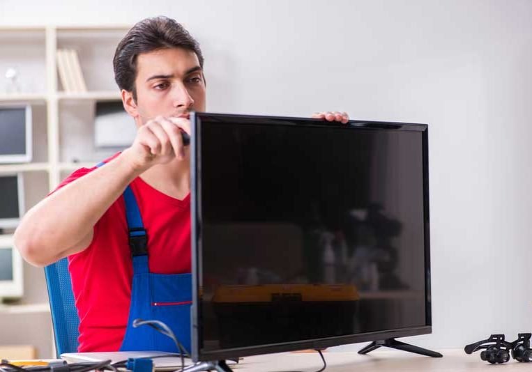 TV Repair Service in Defence Colony by Quick Home Fix technician repairing LED Smart TV at home